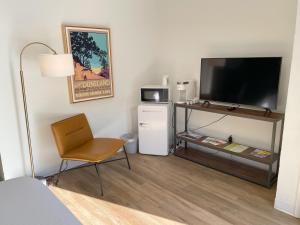 Zimmer mit einem TV und einem Stuhl in einem Zimmer in der Unterkunft Al & Sally's Motel in Michigan City