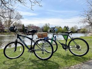 two bikes parked on the grass next to a river at Lake Front Studio with Kayaks Bikes near Greenbelt in Boise