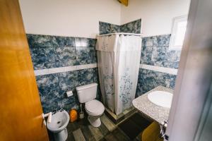 a bathroom with a toilet and a sink at OHANA in Sierra de la Ventana