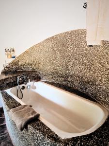 a bath tub in a bathroom with a granite counter top at Munga Eco-Lodge in Livingstone