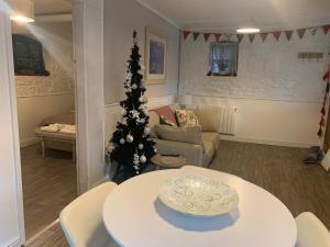a living room with a christmas tree and a table at Coach House in Keighley