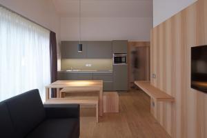 a living room with a table and a kitchen at Residence Larciunei in Ortisei