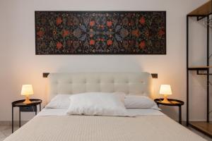 a bedroom with a large bed with two lamps at Locanda del buongustaio in Cagliari