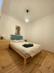 een slaapkamer met een bed en een houten vloer bij Agradable casa rural con suelos de madera in Santa Olalla del Cala