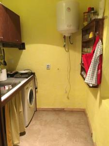 een kleine keuken met een wasmachine in de hoek bij Agradable casa rural con suelos de madera in Santa Olalla del Cala