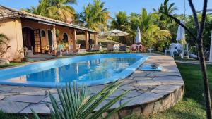 a swimming pool in front of a house at Pousada Entre as Águas in Imbassai