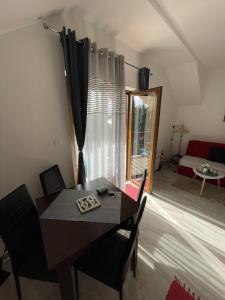 a dining room with a table and chairs and a bedroom at Apartman Gakić 2 in Nova Varoš