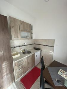 a kitchen with a sink and a table with chairs at Apartman Gakić 2 in Nova Varoš