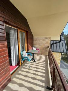 a balcony with two chairs and a table on it at Apartman Gakić 2 in Nova Varoš