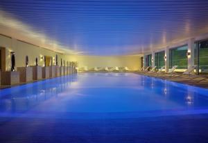 una grande piscina in un edificio con sedie di Coworth Park - Dorchester Collection ad Ascot