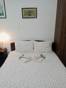 a bedroom with a bed with two shoes on it at Apartman Gakić 2 in Nova Varoš