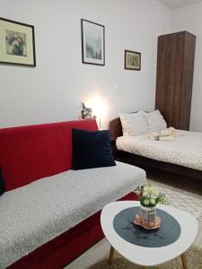 a living room with a red couch and a table at Apartman Gakić 2 in Nova Varoš