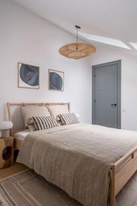 a bedroom with a large bed and a ceiling at Bright Designer Mansard in city centre in Rīga