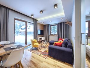 sala de estar con sofá azul y mesa en VisitZakopane - My Deer Apartment en Zakopane