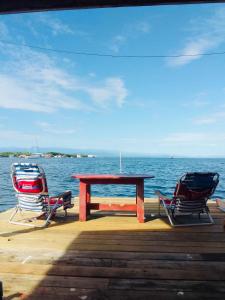 stół piknikowy i dwa krzesła siedzące na doku w obiekcie Casa elba sobre el mar w mieście Bocas del Toro