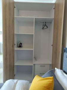 a bedroom with a closet with white shelves at Anmeg Deluxe Rooftop Studio Apartment in Nairobi