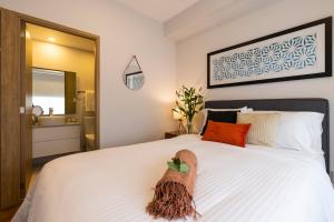 a bedroom with a white bed and a mirror at DOMINION SANTA FE in Mexico City