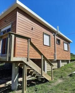 una casa de madera con una rampa que conduce a ella en ALMA VERDE BUNGALOWS, en La Paloma