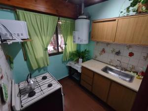a kitchen with a sink and a stove top oven at La Galleguita in Colón +17 photos