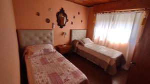 a small bedroom with two beds and a window at La Galleguita in Colón