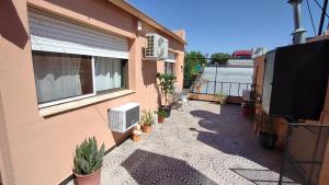a balcony of a house with potted plants and a window at La Galleguita in Colón