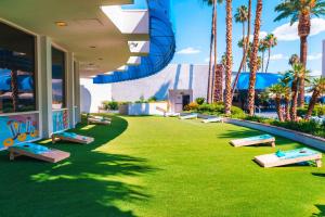 un complexe avec des palmiers et une pelouse avec des bancs dans l'établissement Horseshoe Las Vegas formerly Bally's, à Las Vegas