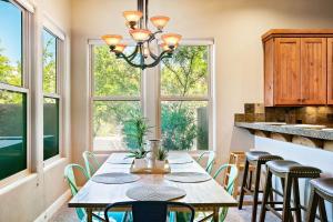 a dining room with a table and chairs and windows at Lava Falls #9 townhouse in Santa Clara