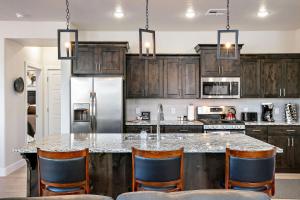 a kitchen with wooden cabinets and a large island with chairs at Just Us and the Sun home in Washington +23 photos