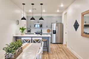 a kitchen with white cabinets and a kitchen island with bar stools at Sun, Sand, and Smiles #100 condo in St. George