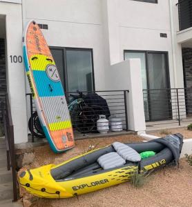 a kayak and a surfboard next to a house at Sun, Sand, and Smiles #100 condo in St. George