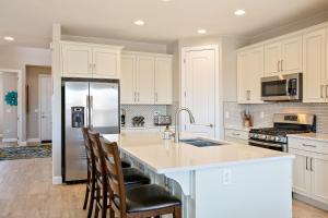 a kitchen with white cabinets and a refrigerator at House It Going home in Washington