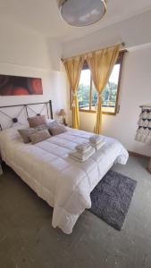 1 dormitorio con 1 cama blanca grande con cortinas amarillas en RECUERDAME en Mendoza