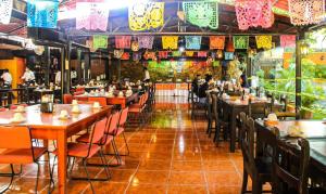 un restaurante con mesas de madera, sillas y luces en Casa Kolping, en Tuxtla Gutiérrez