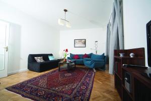 a living room with a blue couch and a rug at Judy and Sandor Apartmen in Budapest