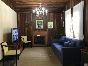 a living room with a blue couch and a fireplace at Lindo e aconchegante chalé com piscina, lareira e churrasqueira in São Roque