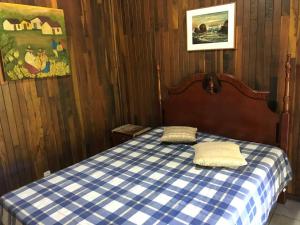 a bedroom with a blue and white checkered bed with two pillows at Lindo e aconchegante chalé com piscina, lareira e churrasqueira in São Roque +37 photos