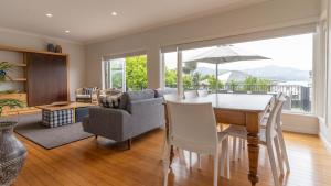 een eetkamer met een tafel en stoelen en een woonkamer bij Spacious Sunny Family Home in Akaroa in Akaroa