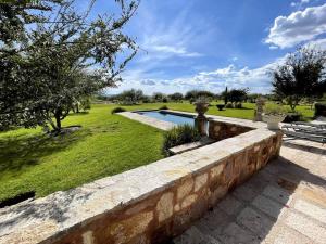 una pared de piedra junto a un patio con piscina en RANCHO SAVANHA en Guanajuato