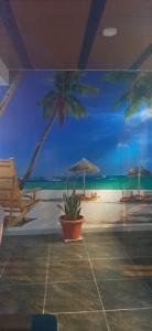 吉拉爾的住宿－Hotel Acapulco，海滩壁画,上面摆放着椅子和遮阳伞