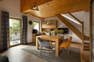 a kitchen and dining room with a table and chairs at Apartamenty u Harrego II Przy Stawie Spa in Kudowa-Zdrój