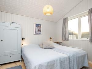 1 dormitorio blanco con 1 cama y 2 ventanas en Holiday home Sæby CXXI, en Saeby