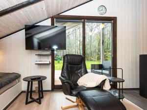 sala de estar con silla y TV de pantalla plana en Holiday home Oksbøl LXXVIII en Oksbøl