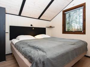 Un dormitorio con una cama grande y una ventana en Holiday home Oksbøl LXXVIII en Oksbøl