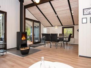 a living room with a fireplace and a dining room at Holiday home Oksbøl LXXVIII in Oksbøl
