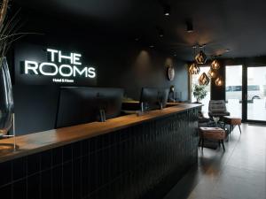 a bar in a restaurant with a sign on the wall at THE ROOMS - Hotel & House in Frankfurt/Main