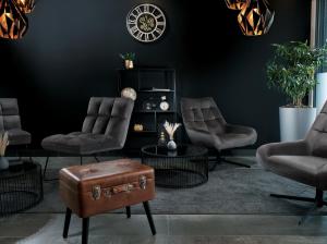 a living room with chairs and a table with a suitcase at THE ROOMS - Hotel & House in Frankfurt +77 photos