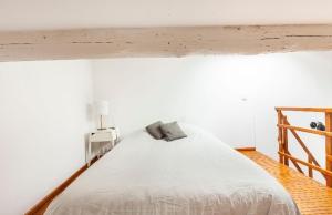 a bedroom with a white bed with a wooden frame at Le 7 in Sète