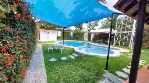 - un parasol bleu dans une cour avec une piscine dans l'établissement Casa Kolping, à Tuxtla Gutiérrez