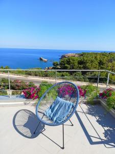 a blue chair on a balcony with a view of the ocean at Zabbàra B&B in Terrasini