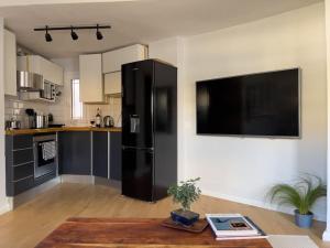 a black refrigerator in a kitchen with a table at Homevision - Stylish & Serene Condo - City Center in Thessaloniki